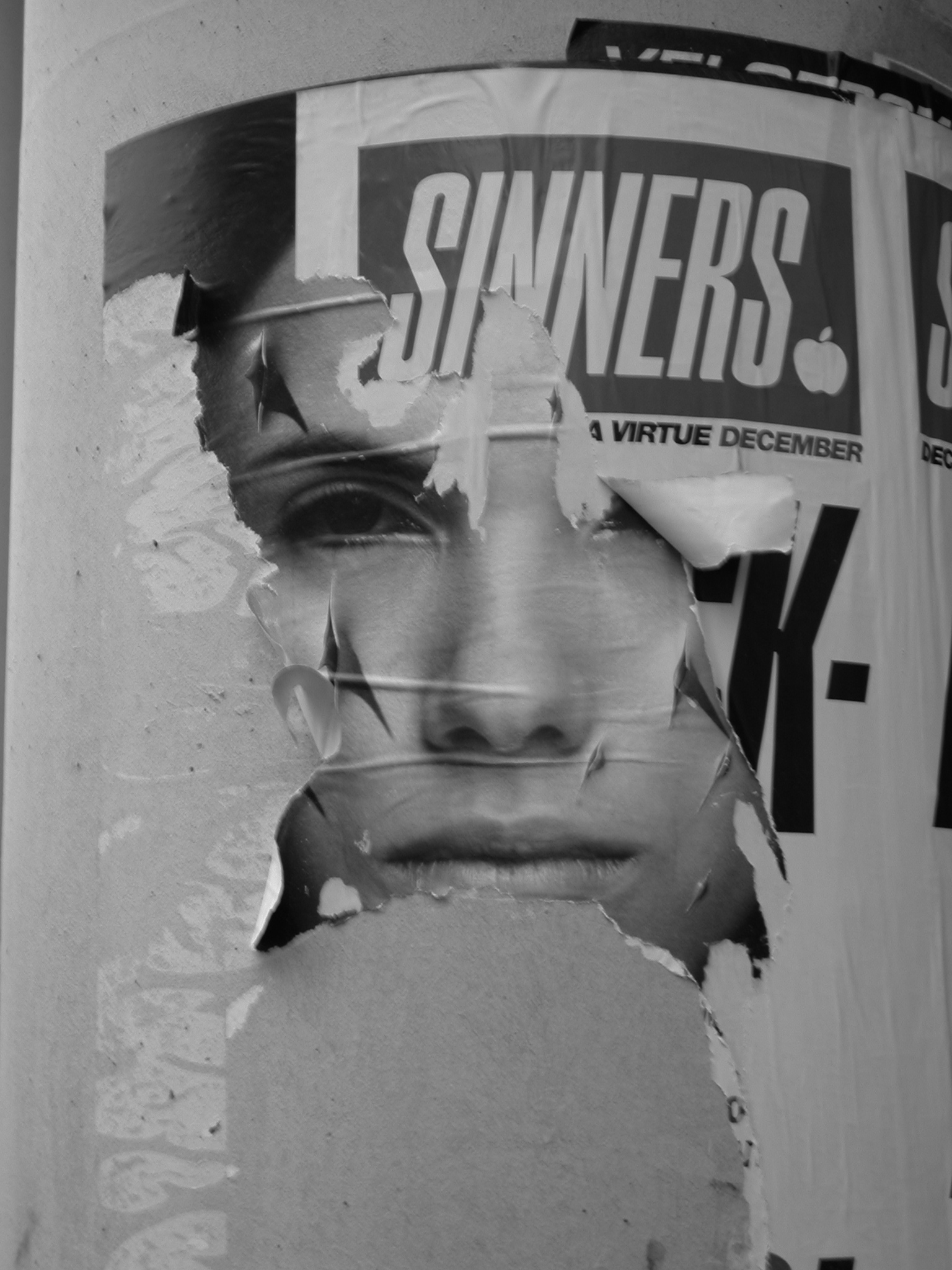 sinners girl face posters on pole torn worn