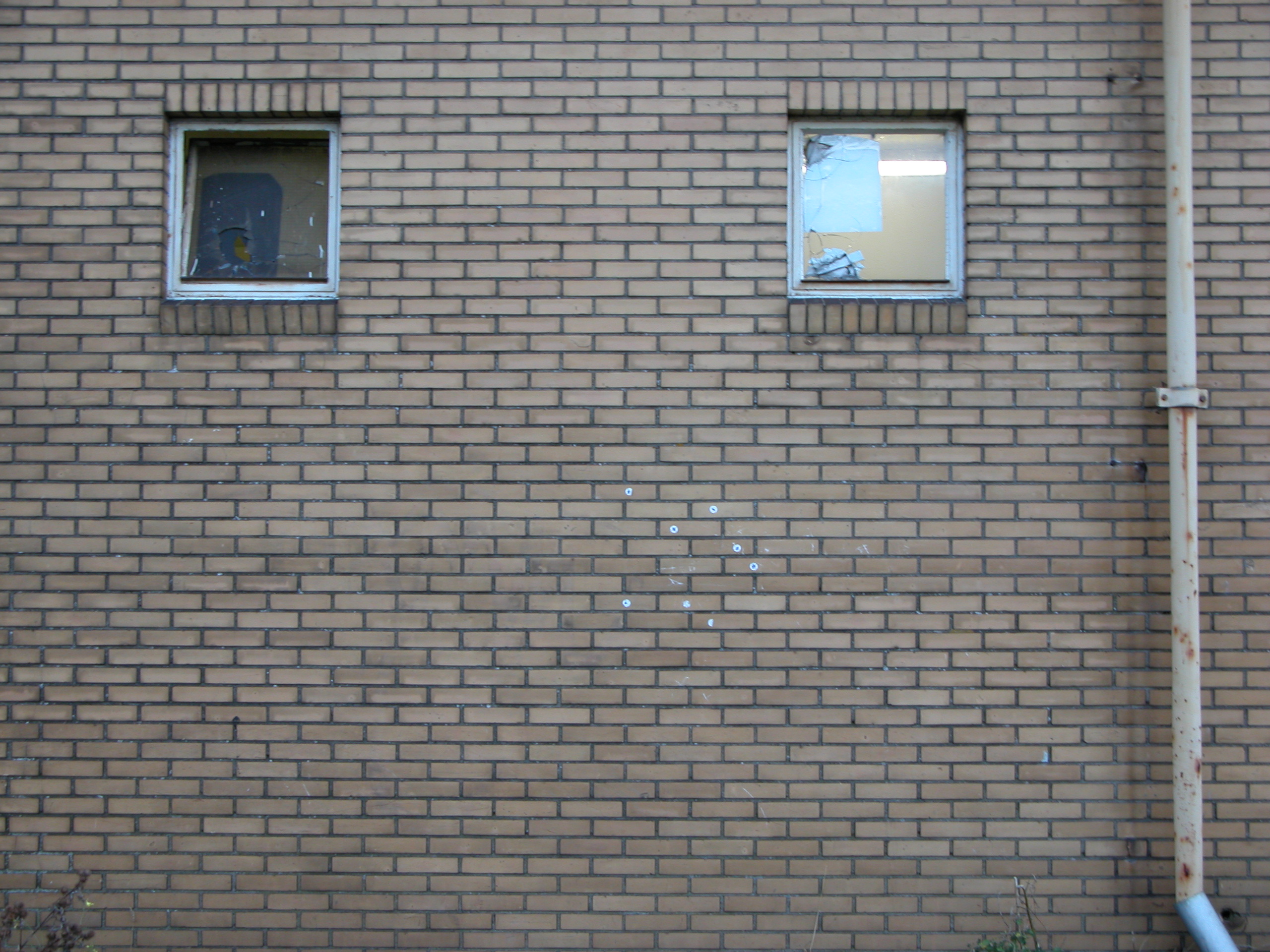 brick wall with two 2 windows rainpipe station house