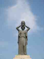 michieldeboer statue torch high lady greek holding mask aloft