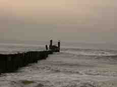 paul sea waves spray pier seagulls poles