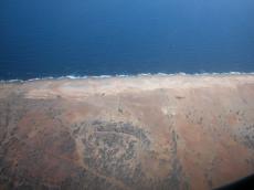 landscape from airplane aerial photo roads brown sea waves plane shadow