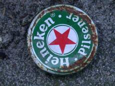 beer heineken dutch cap bottlecap green red star larger alcohol round thrown away old worn rubbish
