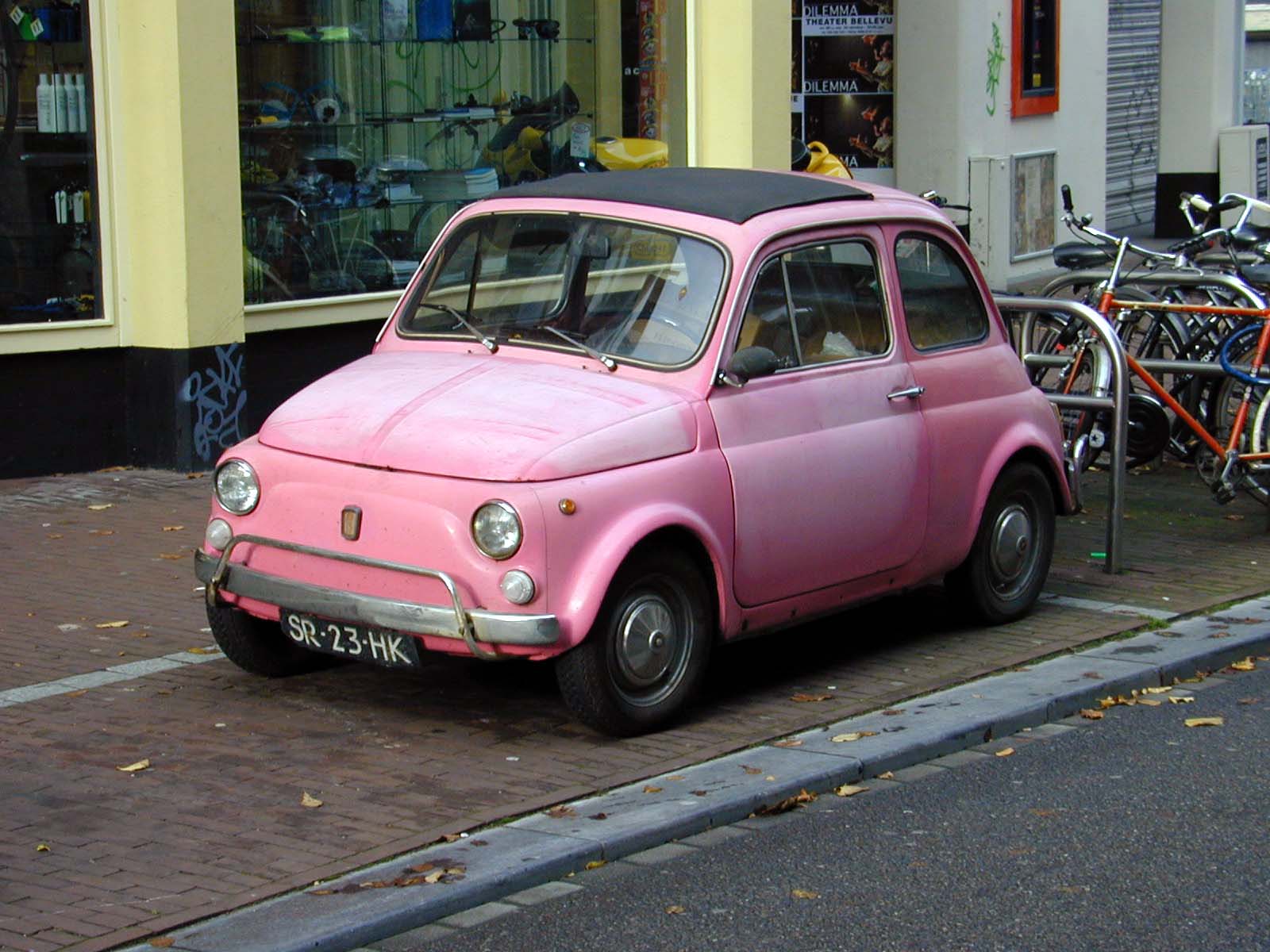 pink cadillac fiat 500 cinquecento car parked street