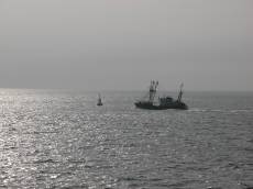ship fisher on open sea ocean water grey sky