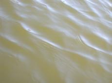 brown dirty clouded water little waves surface