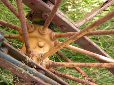 wheel spoke spokes yellow grass metal rust