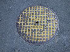 lid yellow painted circle drain sewer metal street grounds asphalt