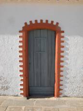 door green red ornate bricks white plaster wall