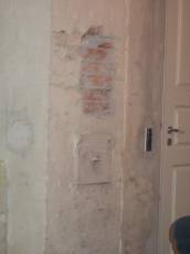 tabus wall bricks underneath plaster painted door handle white